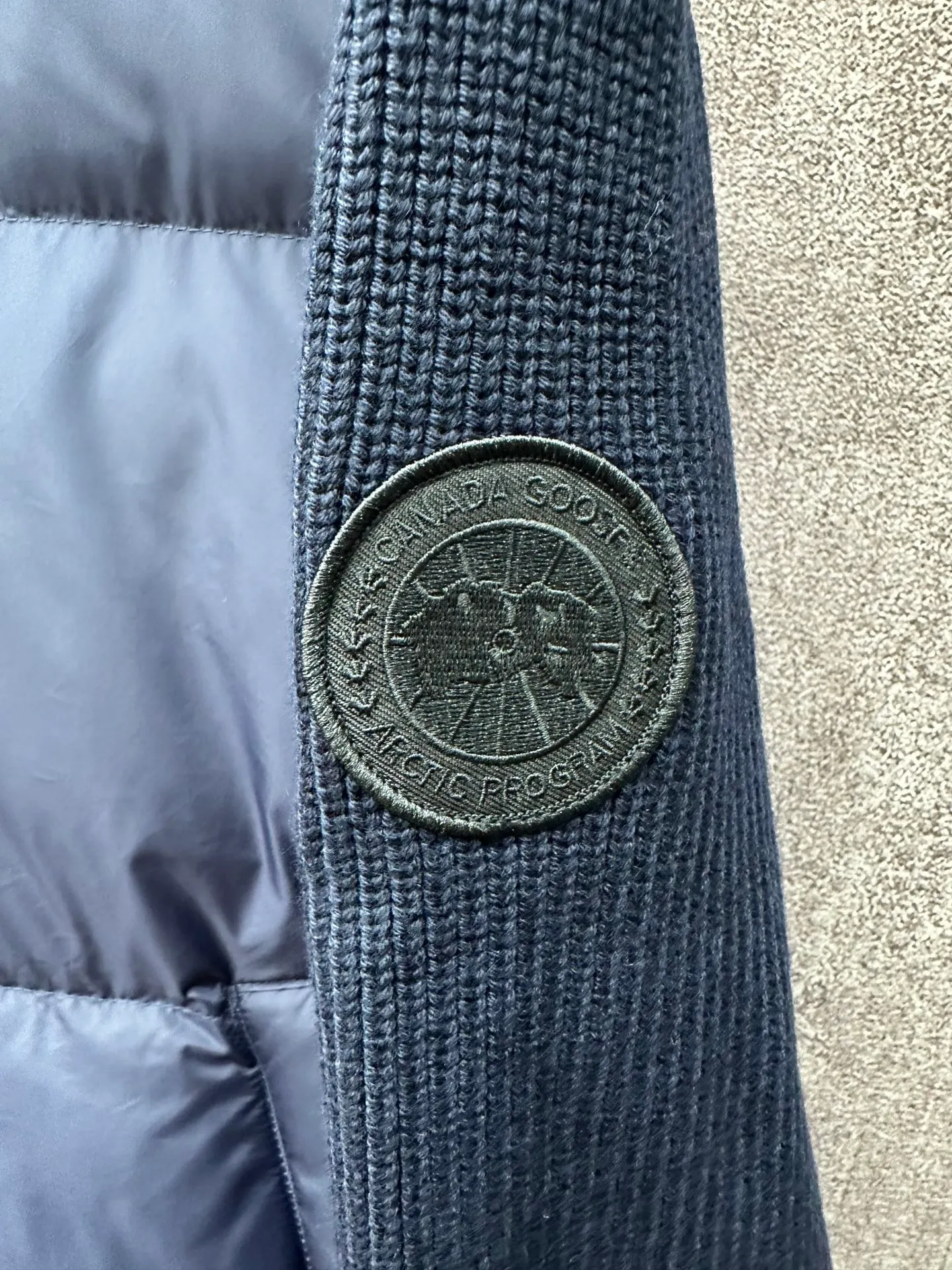 P930 Canada Goose Armband Hooded Down Jacket Fabric selection: The use of high-quality protective nylon fabric not only enhances the wear resistance of the surface, but also takes into account wind resistance, ensuring excellent performance in various harsh weather conditions.  90 national standard high-quality white duck down: selected high-loft down, weighing 170g, light and warm, with excellent temperature locking performance and good resilience.  Three-dimensional quilting process: Precision thread reinforcement to prevent velvet drilling and ensure that the fluffy and resilient elasticity lasts as new.  7-needle medium-thick knitted structure: Use thicker yarns to knit woolen fabrics with obvious thickness and weight. The texture is clearly visible and has a rough, retro texture. It has a good skeleton feel, is relatively stiff, and can maintain the silhouette of clothing for a long time. It also provides more layers of still air to lock in heat.  There is a brand exclusive LOGO on the woolen sleeve arms. It is dark and not obvious in the photo.  Accessories: One-to-one customized logo, one-to-one customized zipper pendant, one-to-one customized snap button SIZE: S M L XL
